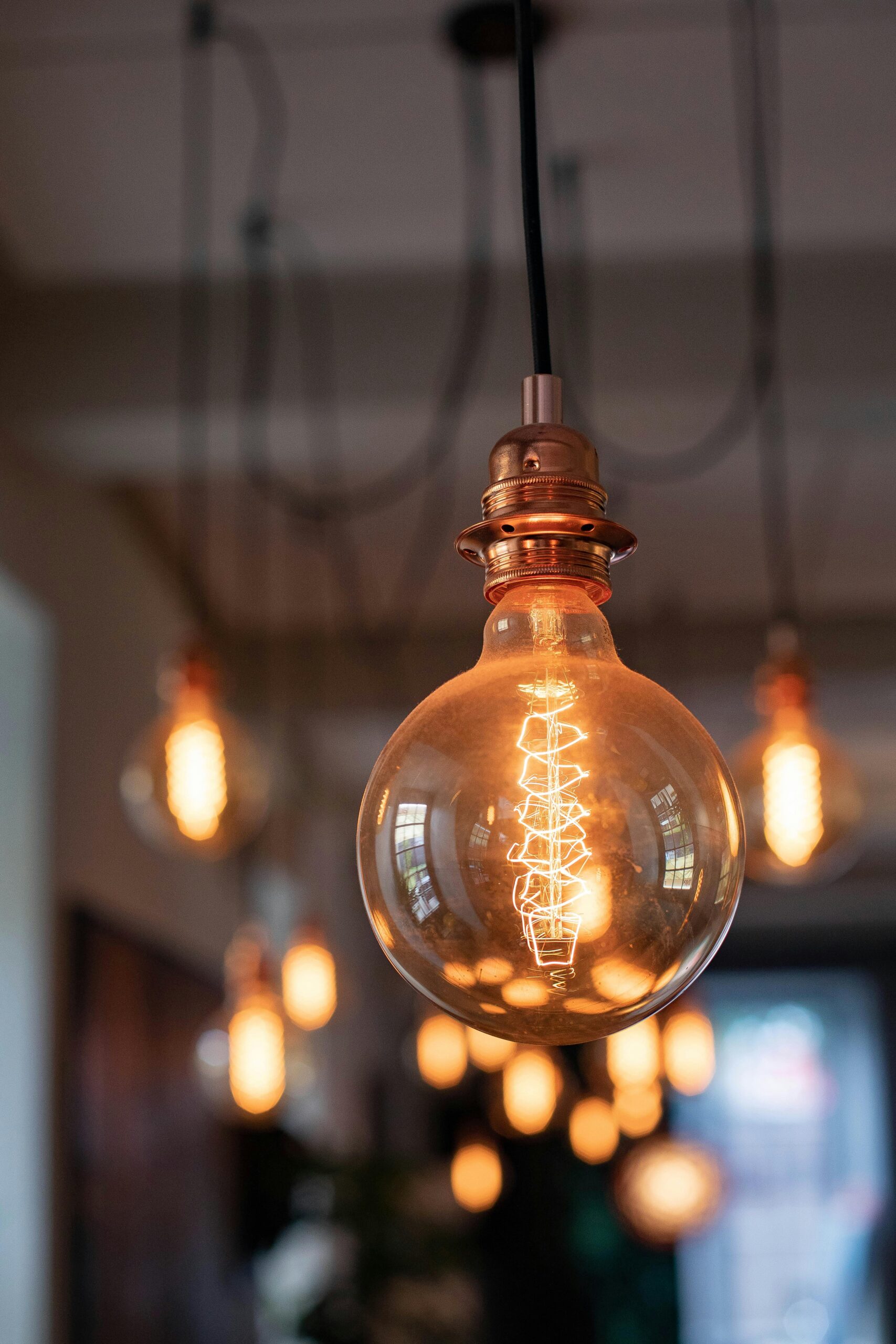 Close-up of vintage Edison-style light bulbs glowing warmly in a modern indoor setting.